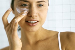 mujer aplicando crema facial