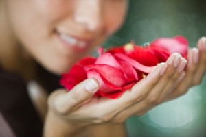 Mujer oliendo pétalos de flores