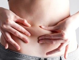 Mujer pinzándose la barriga