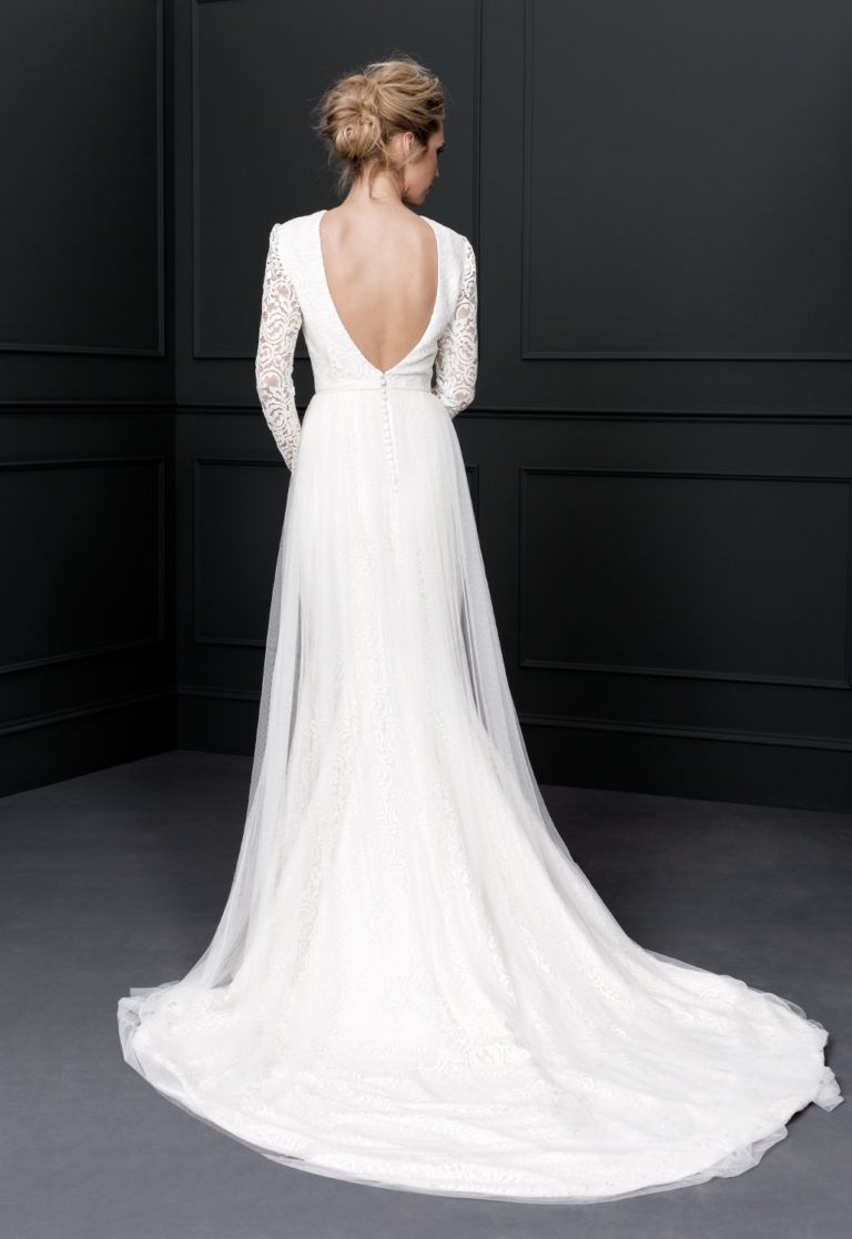 Este vestido manga larga elaborado en encaje rebrodé, también destaca con elegancia la espalda. Un diseño nupcial perfecto para una boda ideal con la falda de encaje con sobrefalda de tul de seda.